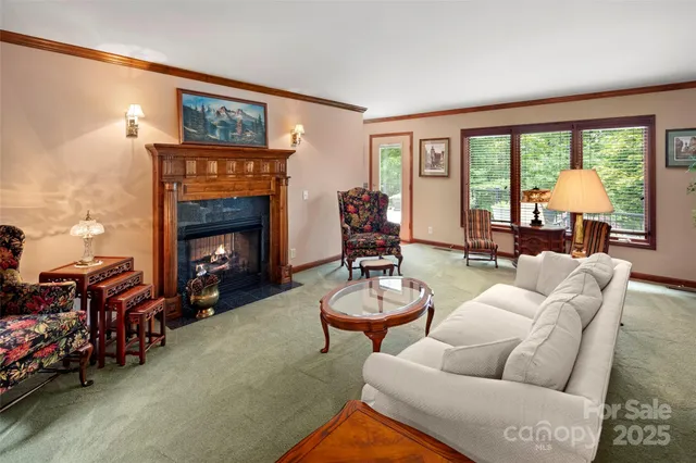 a living room with furniture a fireplace and a large window