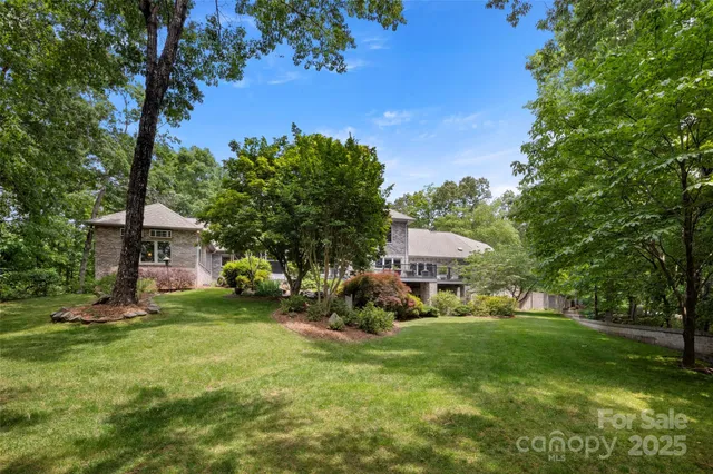 a view of a house with a big yard and large trees
