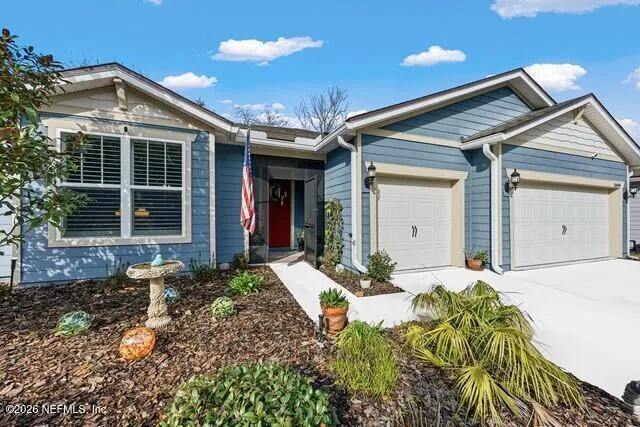 a front view of a house with a yard and potted plants