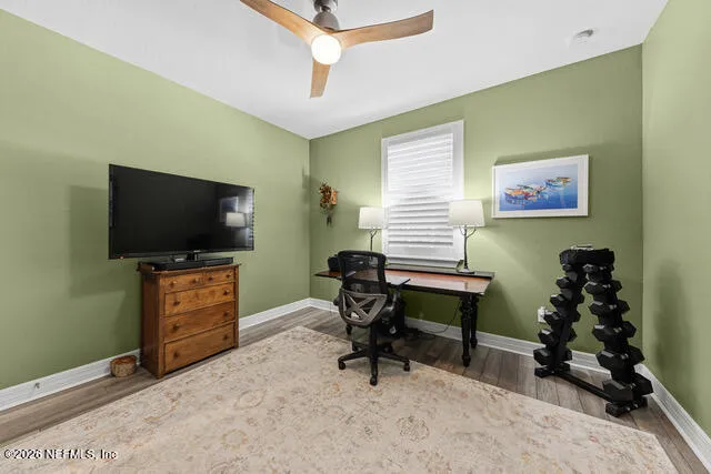 a living room with furniture floor to ceiling window and wooden floor
