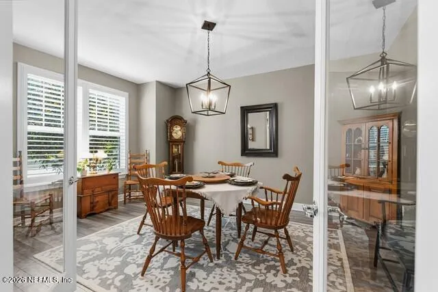 a large white kitchen with a large island oven a sink dishwasher and a large refrigerator with wooden floor