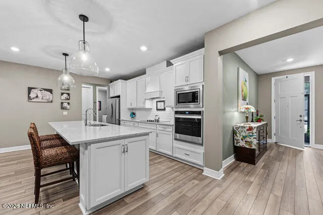 a kitchen with stainless steel appliances granite countertop a sink dishwasher a refrigerator and a stove