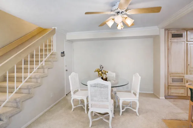 a dining room with furniture and chandelier fan