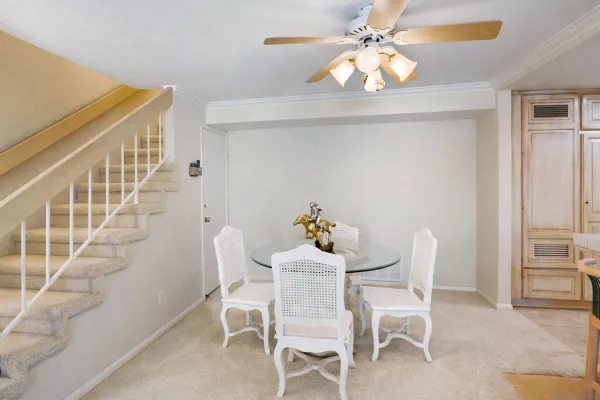 a dining room with furniture and chandelier fan