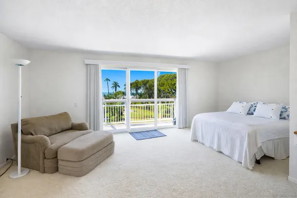a spacious bedroom with a bed and a couch next to a window