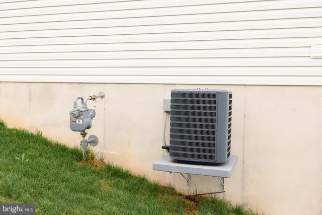 a view of a white house next to a yard with big trees