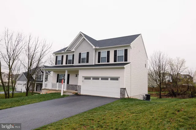 a front view of a house with a garden and yard