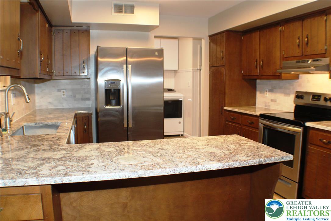 909 Wood Road Danielsville, PA 18038 - Photo 21 of 56 a kitchen with stainless steel appliances granite countertop a sink a stove and a refrigerator