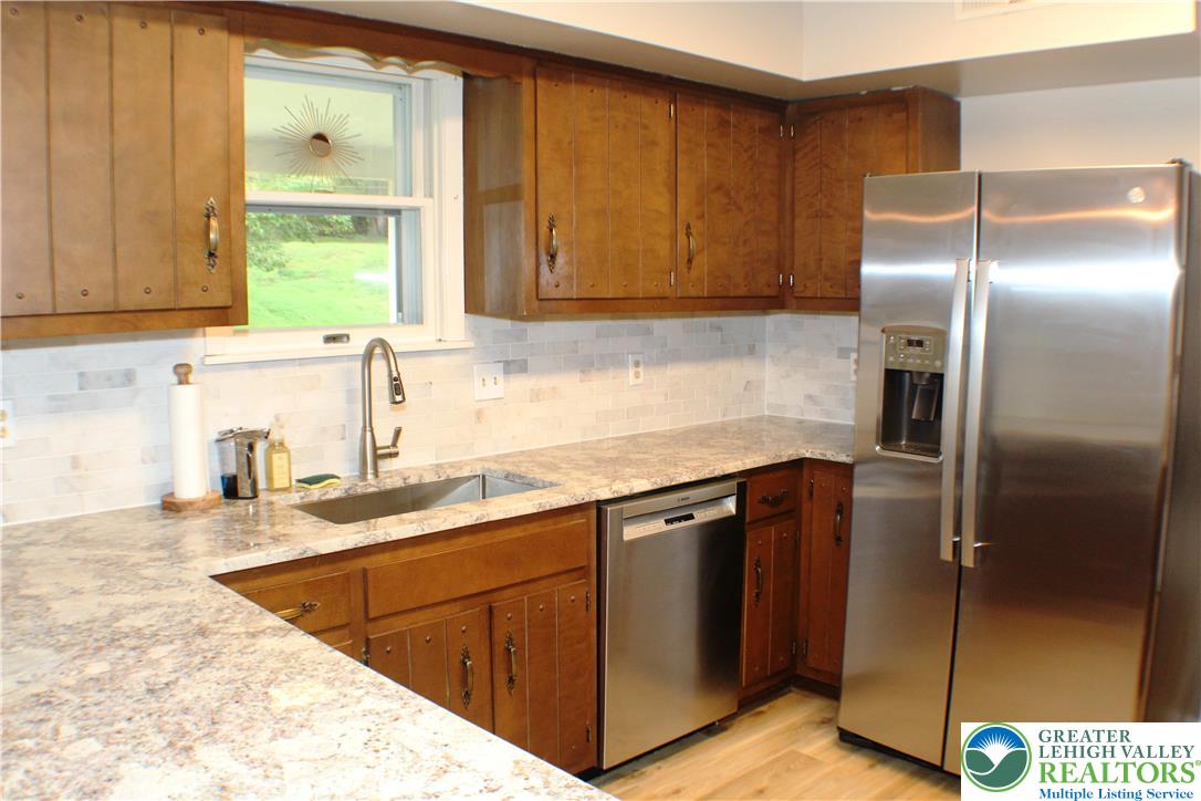 909 Wood Road Danielsville, PA 18038 - Photo 22 of 56 a kitchen with stainless steel appliances granite countertop a sink stove and refrigerator