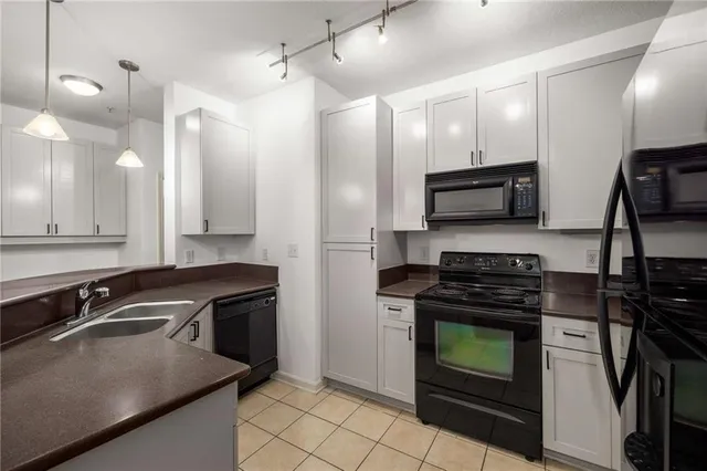 a kitchen with stainless steel appliances a stove a sink a microwave a refrigerator and cabinets