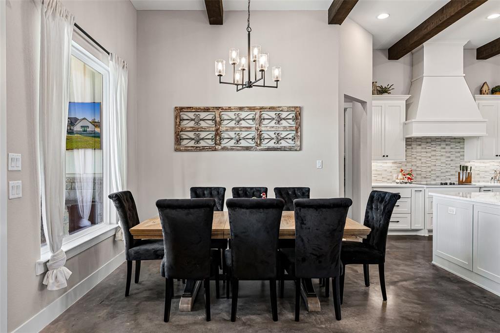 310 Runyan Rnch Road Tolar, TX 76476 - Photo 17 of 35 Dining room with concrete floors, a chandelier, and beam ceiling