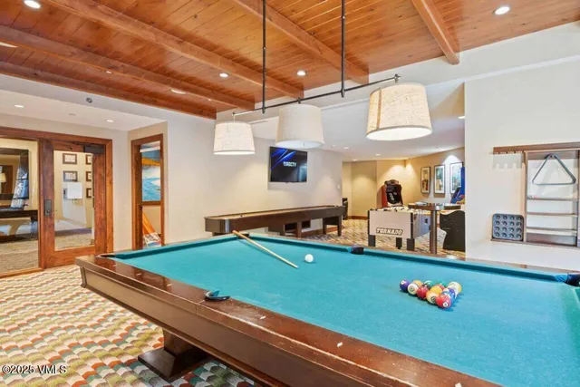 a room with furniture pool table and flat screen tv