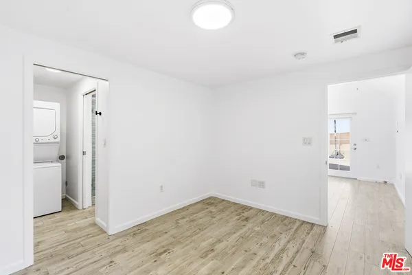 a view of a room with wooden floor and a bathroom