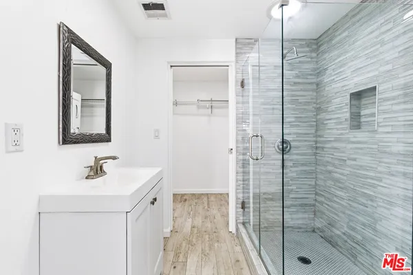 a bathroom with a shower sink and mirror