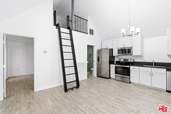 a kitchen with stainless steel appliances a refrigerator and a stove top oven