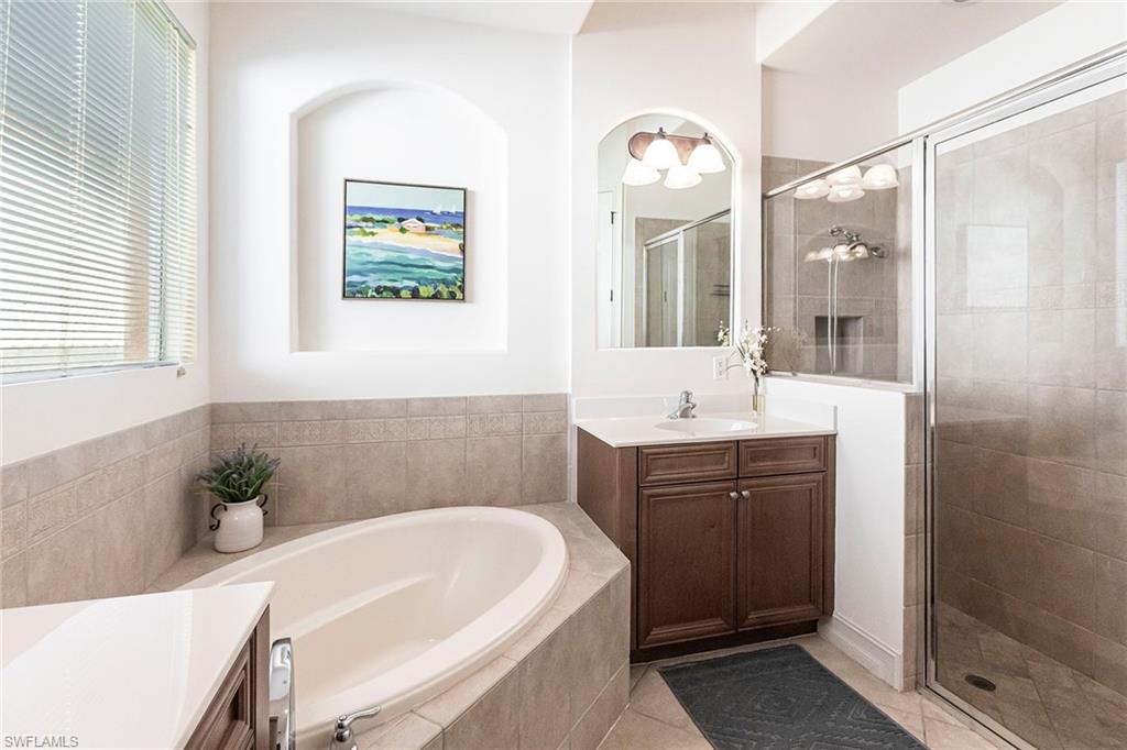 7863 Valencia Court Naples, FL 34113 - Photo 27 of 50 a bathroom with a tub sink and mirror