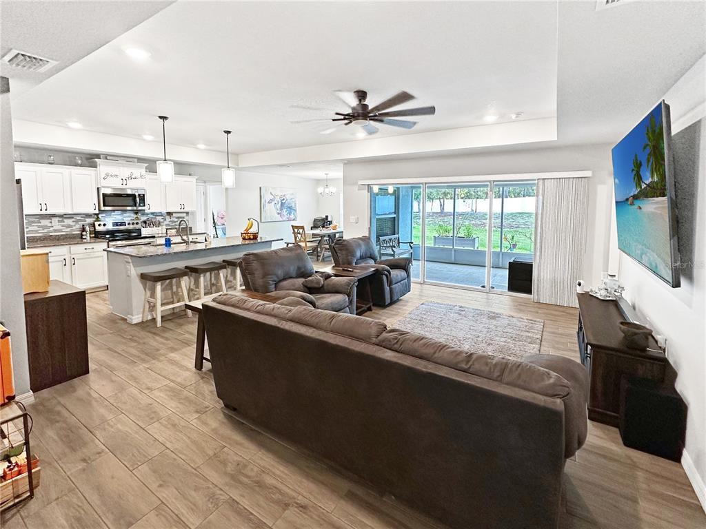 13023 Downy Woodpecker Road Weeki Wachee, FL 34614 - Photo 12 of 43 a living room with stainless steel appliances furniture a flat screen tv and a kitchen view