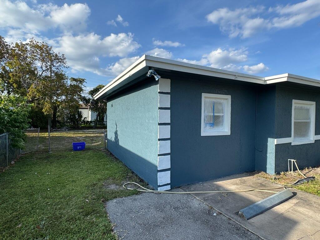 112 West 34th Street, Unit 1 Riviera Beach, FL 33404 - Photo 3 of 23 a backyard of a house with wooden fence and a lots of green space