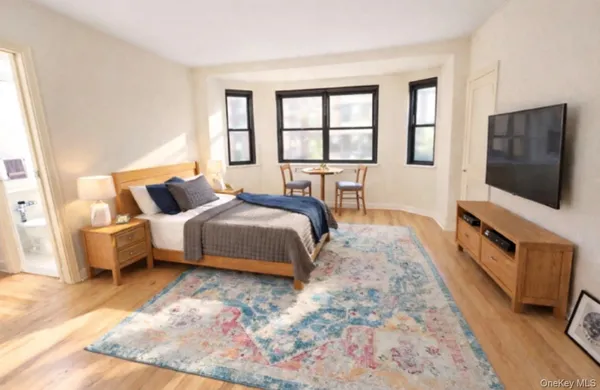 a spacious bedroom with a bed and a flat screen tv