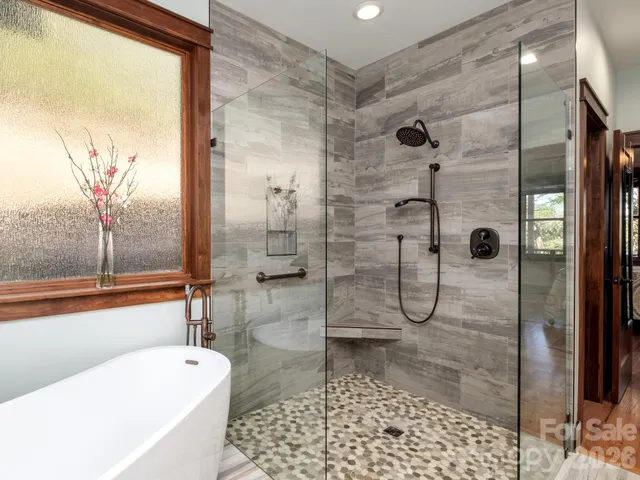 a bathroom with a granite countertop sink a mirror a bathtub and shower