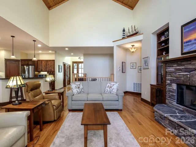 a kitchen with stainless steel appliances kitchen island granite countertop a refrigerator a stove a microwave oven a sink with island chairs and wooden floor