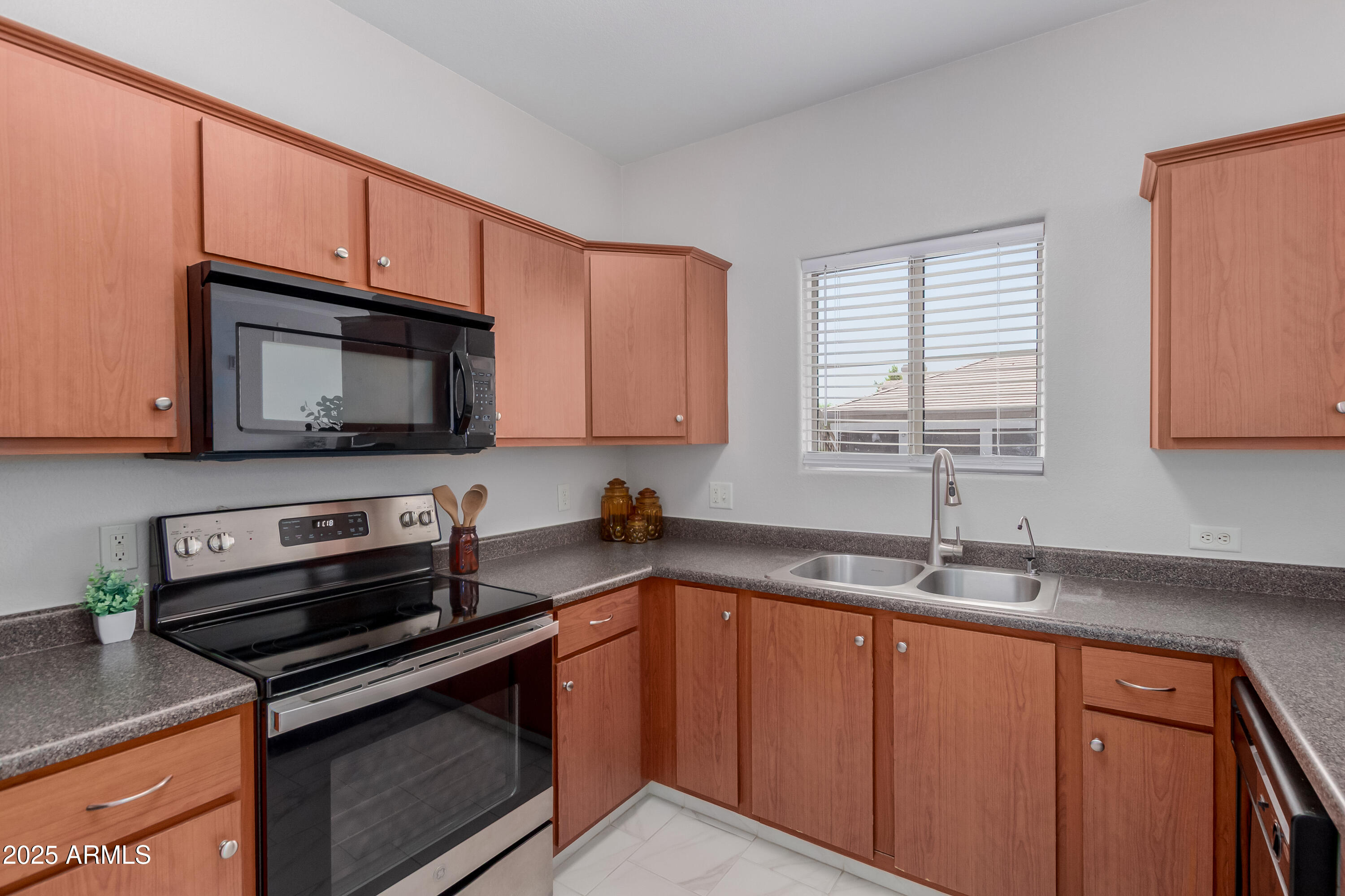 1941 South Pierpont Drive, Unit 1114 Mesa, AZ 85206 - Photo 11 of 34 a kitchen with granite countertop a sink dishwasher stove and microwave with wooden cabinets
