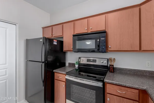 a kitchen with granite countertop a refrigerator stove and microwave