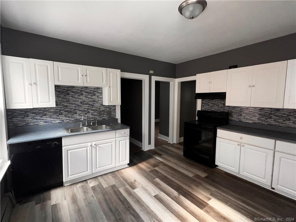 552 Winthrop Avenue New Haven, CT 06511 - Photo 2 of 12 a kitchen with granite countertop a refrigerator a sink dishwasher and white cabinets with wooden floor