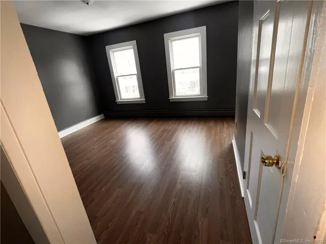 a view of an empty room with wooden floor