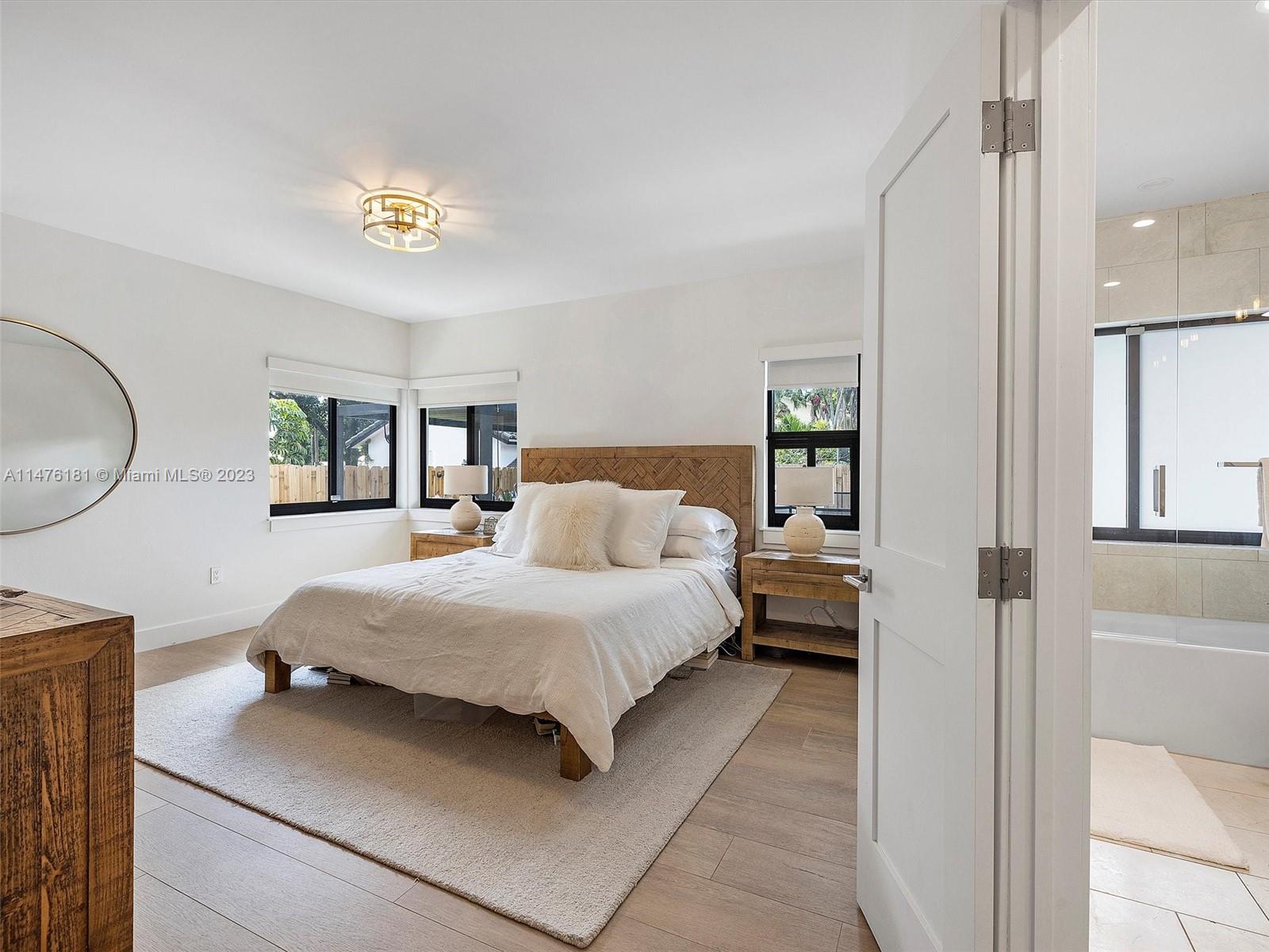 3776 Southwest 107th Court Miami, FL 33165 - Photo 25 of 45 a spacious bedroom with a bed a mirror and lamp