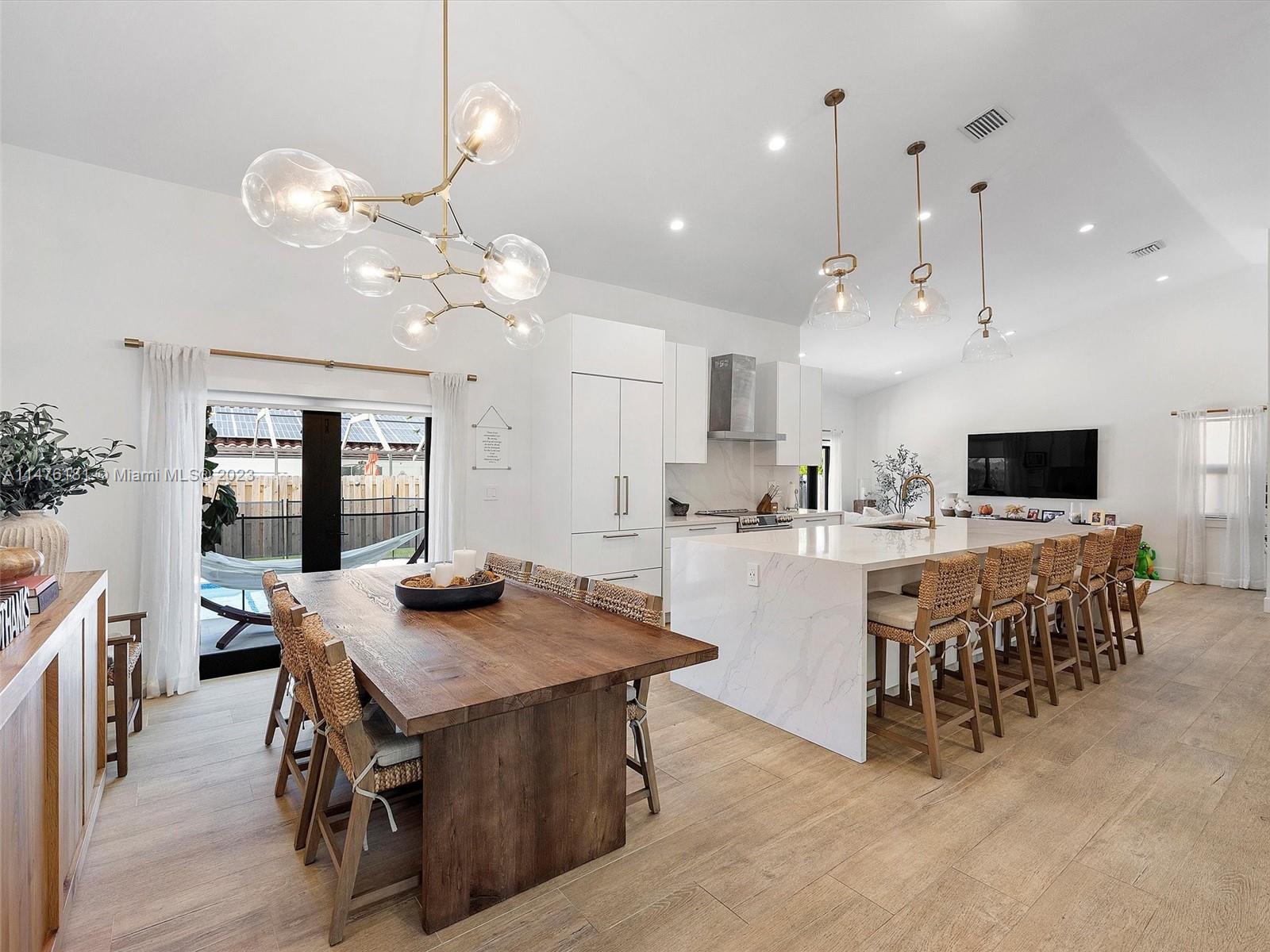 3776 Southwest 107th Court Miami, FL 33165 - Photo 3 of 45 a kitchen with kitchen island a dining table and chairs