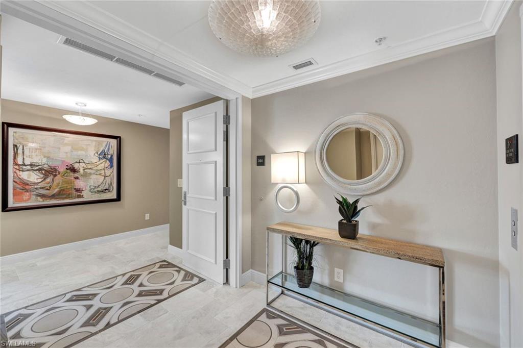 265 Indies Way, Unit T1 Naples, FL 34110 - Photo 13 of 21 a bedroom with a bed and a mirror