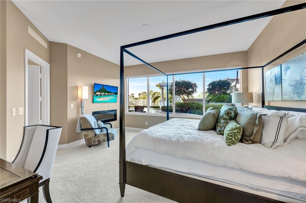 265 Indies Way, Unit T1 Naples, FL 34110 - Photo 5 of 21 a bedroom with a bed and large windows