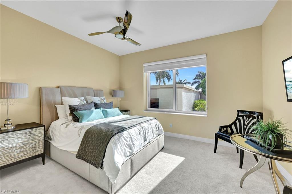 265 Indies Way, Unit T1 Naples, FL 34110 - Photo 7 of 21 a bedroom with a bed a painting on the wall and a window