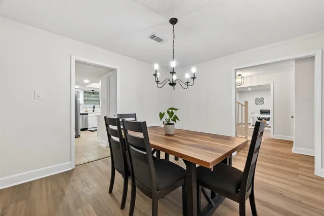 a view of a dining room with furniture wooden floor and a chandelier