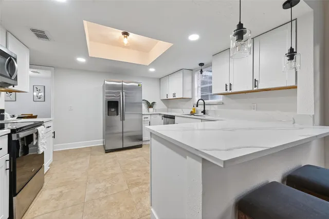 a kitchen with stainless steel appliances granite countertop a sink a stove and a refrigerator
