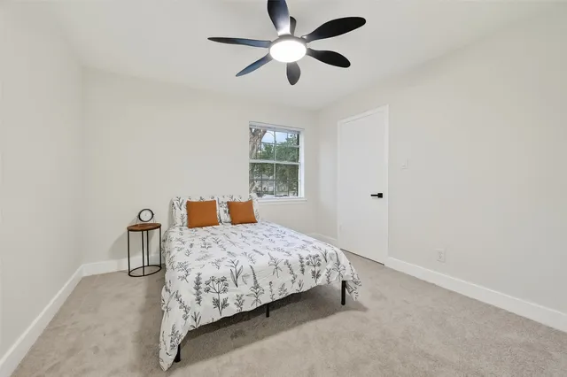 a bedroom with a bed chandelier and window