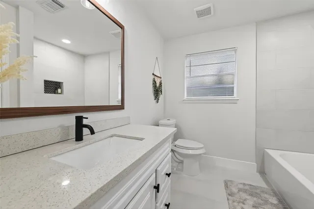 a bathroom with a sink a toilet and mirror