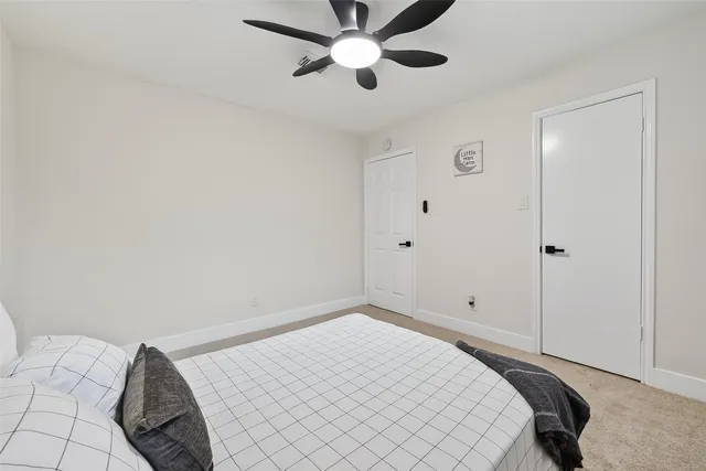 a bedroom with a bed and a ceiling fan