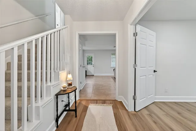 a view of a hallway with wooden floor and staircase