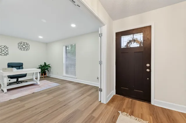 wooden floor in a hall with an entryway door