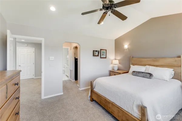 a bedroom with a bed and a flat tv screen on dresser