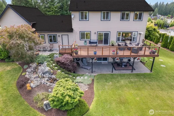 a view of a patio with couches chairs potted plants and wooden floor