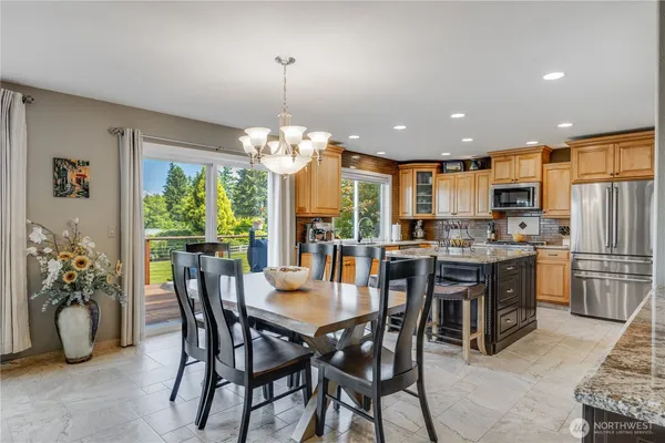 a view of a dining room and a kitchen with a table chairs