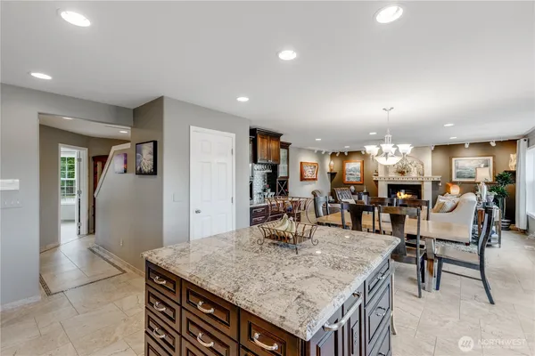 a kitchen with stainless steel appliances granite countertop a table and chairs