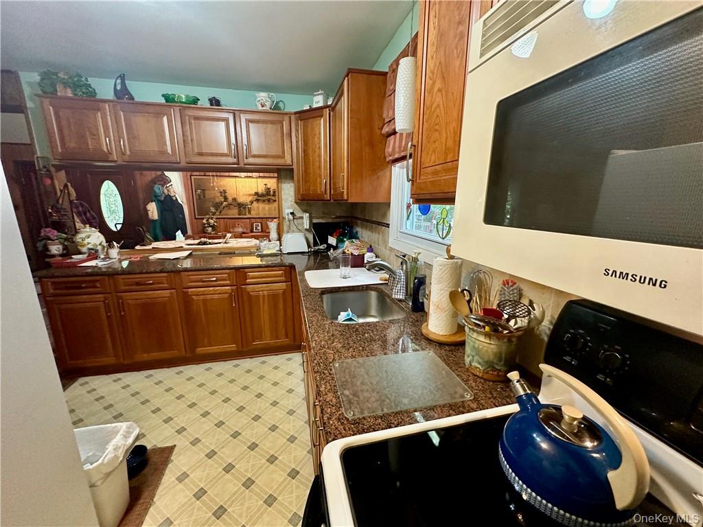 74 Swinging Bridge Estate Road Monticello, NY 12701 - Photo 17 of 36 Kitchen with sink, light tile patterned flooring, and range