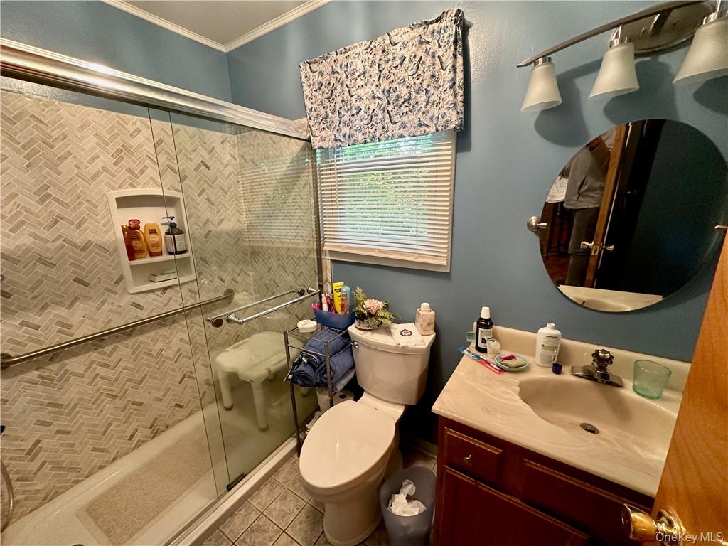 74 Swinging Bridge Estate Road Monticello, NY 12701 - Photo 18 of 36 Bathroom with toilet, tile patterned flooring, vanity, walk in shower, and crown molding
