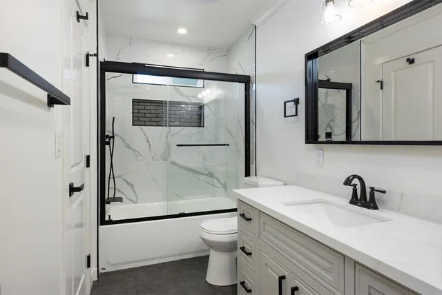 a bathroom with a shower a sink and mirror