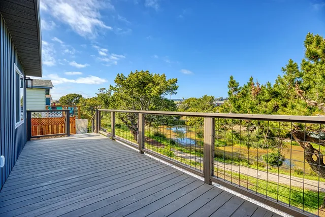 a view of a balcony with floor to ceiling windows and wooden fence