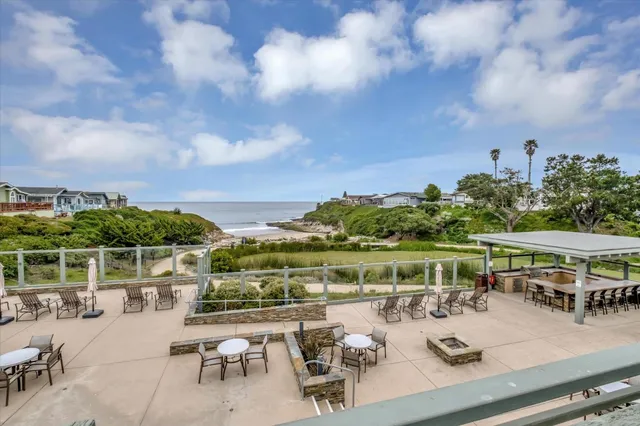 a view of an ocean from a balcony with furniture